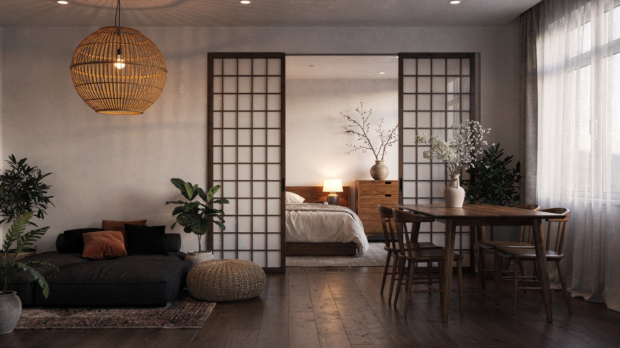 Sliding wood-framed panel doors separating a compact sleeping nook from the main living and dining area of a studio flat